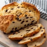 Loaf of Irish Soda Bread on wooden board partially sliced