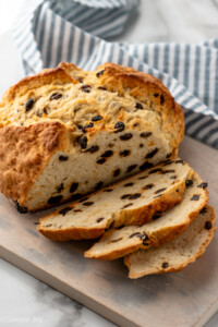 Loaf of Irish Soda Bread on wooden board partially sliced