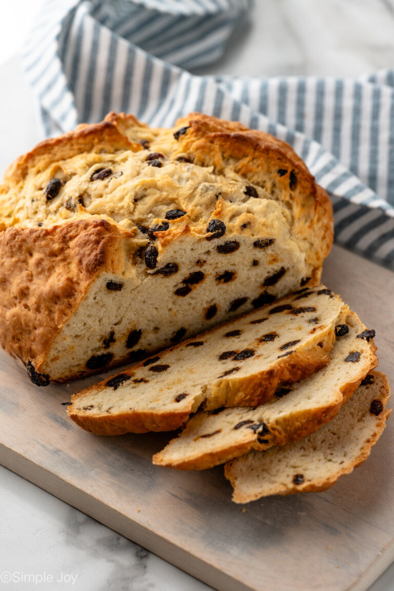 Loaf of Irish Soda Bread on wooden board partially sliced