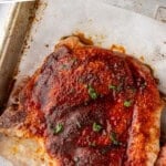 Pinterest graphic for Baked Pork Chops. Says "the best Baked Pork Chops simplejoy.com" Image shows closeup of a baked pork chop on a parchment lined baking sheet