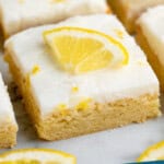 Pinterest graphic for Lemon Sugar Cookie Bars recipe. Image shows Lemon Sugar Cookie Bars with lemon wedge on top. Text says, "Lemon Sugar Cookie Bars simplejoy.com."
