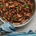 Pinterest graphic for Mongolian Beef. Image shows overhead of Mongolian Beef in a skillet. Says "Mongolian Beef simplejoy.com"