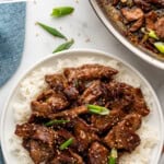 Pinterest graphic for Mongolian Beef. Says "the best Mongolian Beef simplejoy.com" Image shows overhead of a plate of Mongolian Beef and white rice.