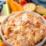 Pinterest graphic for Pimento Cheese recipe. Text says, "the best Pimento Cheese simplejoy.com." Image shows a bowl of Pimento Cheese surrounded by crackers and sliced vegetables.