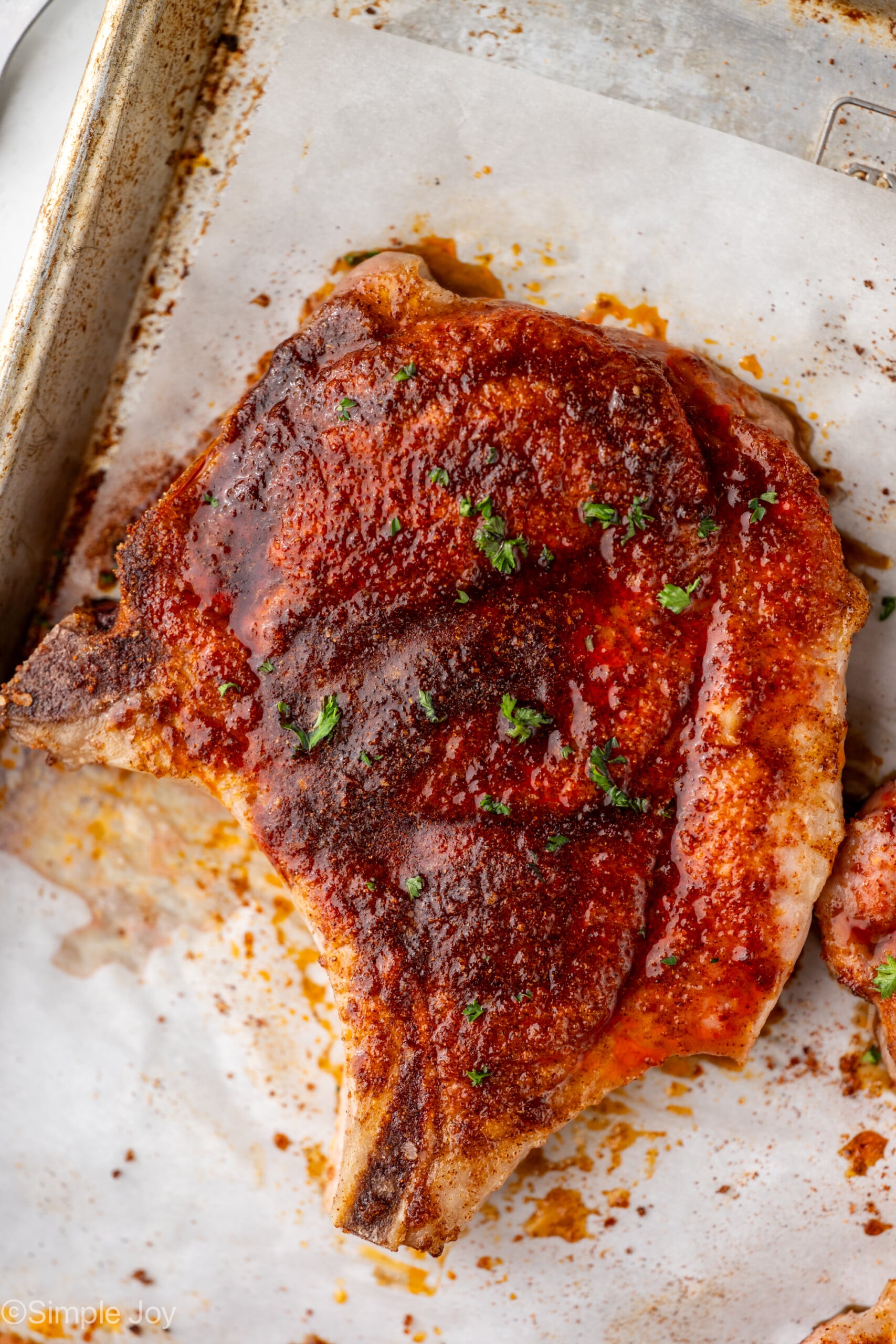 Overhead of a baked pork chop on a baking sheet