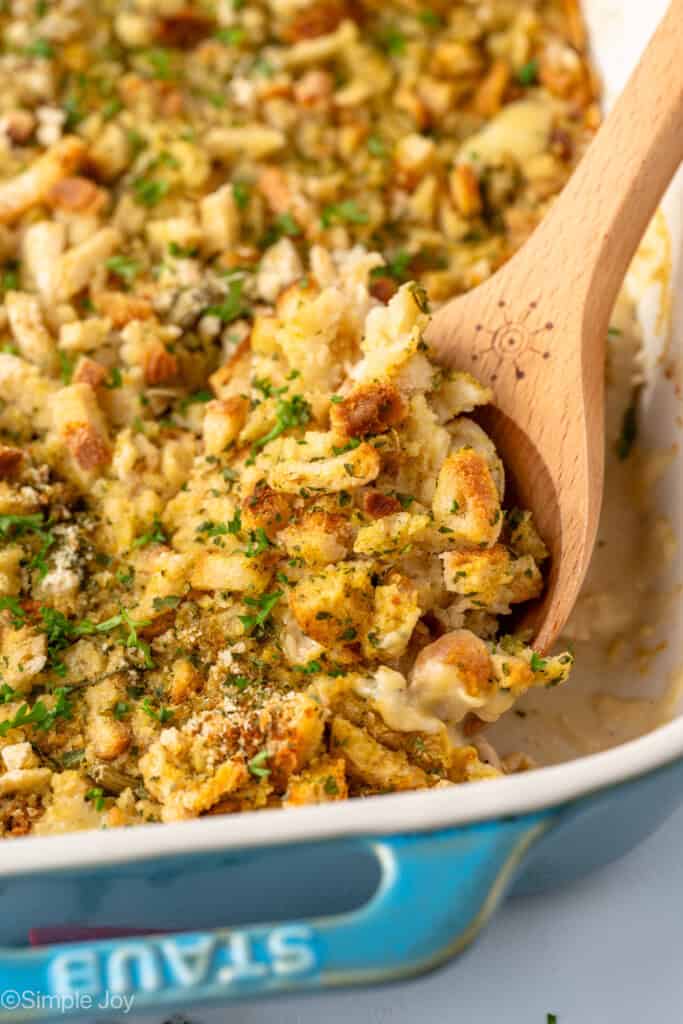 Baking dish of Chicken and Stuffing Casserole with wooden spoon