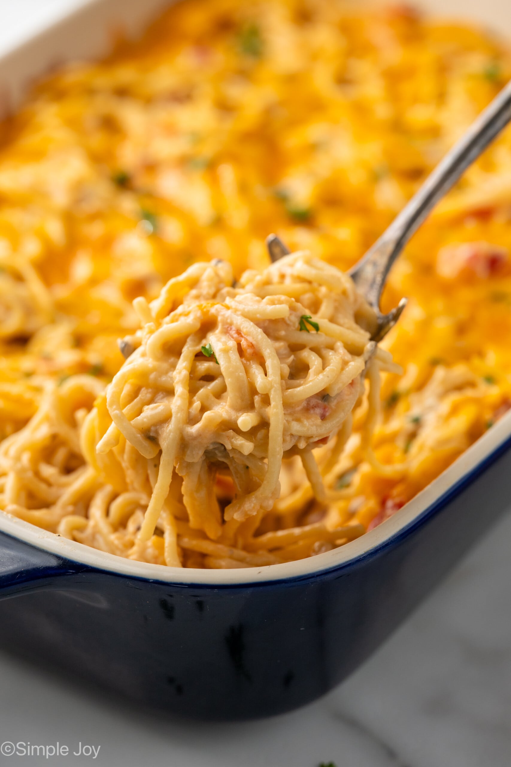 Serving spoon scooping Chicken Spaghetti out of baking dish