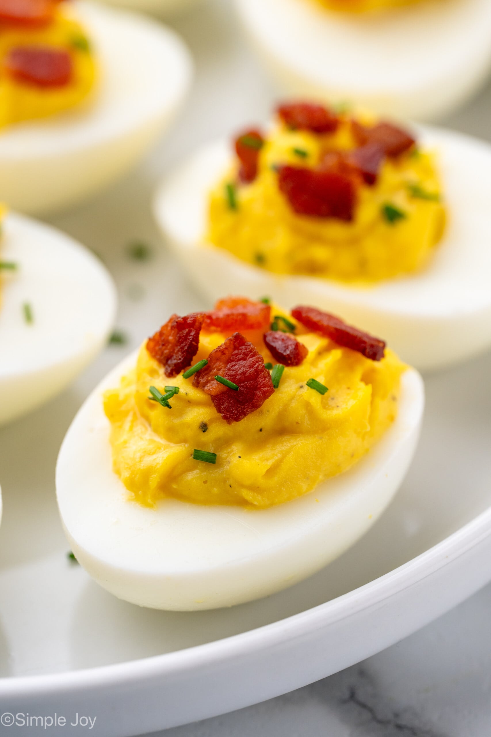 Close up view of Deviled Eggs with Bacon topped with fresh chives