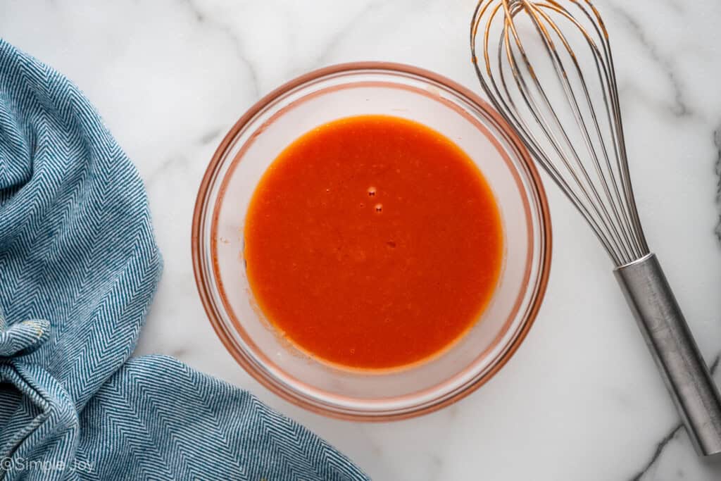 Overhead of glass bowl of Catalina Dressing with whisk sitting beside