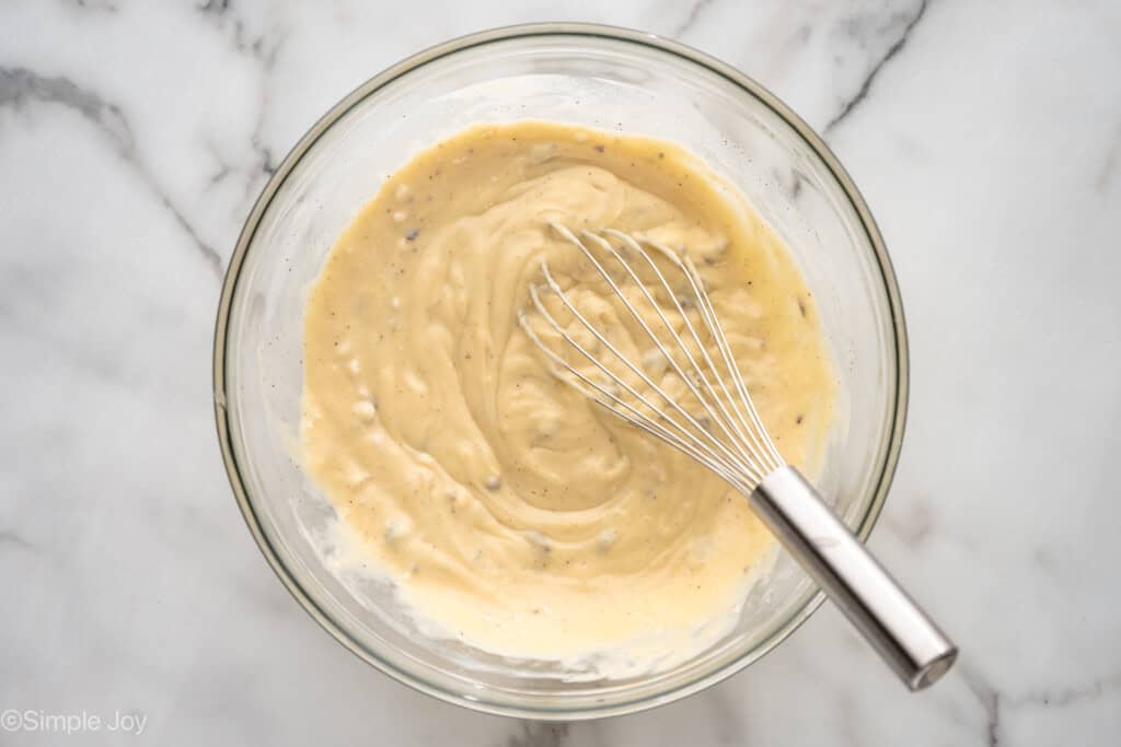 Overhead view of a mixing bowl of ingredients for Chicken and Stuffing Casserole with whisk
