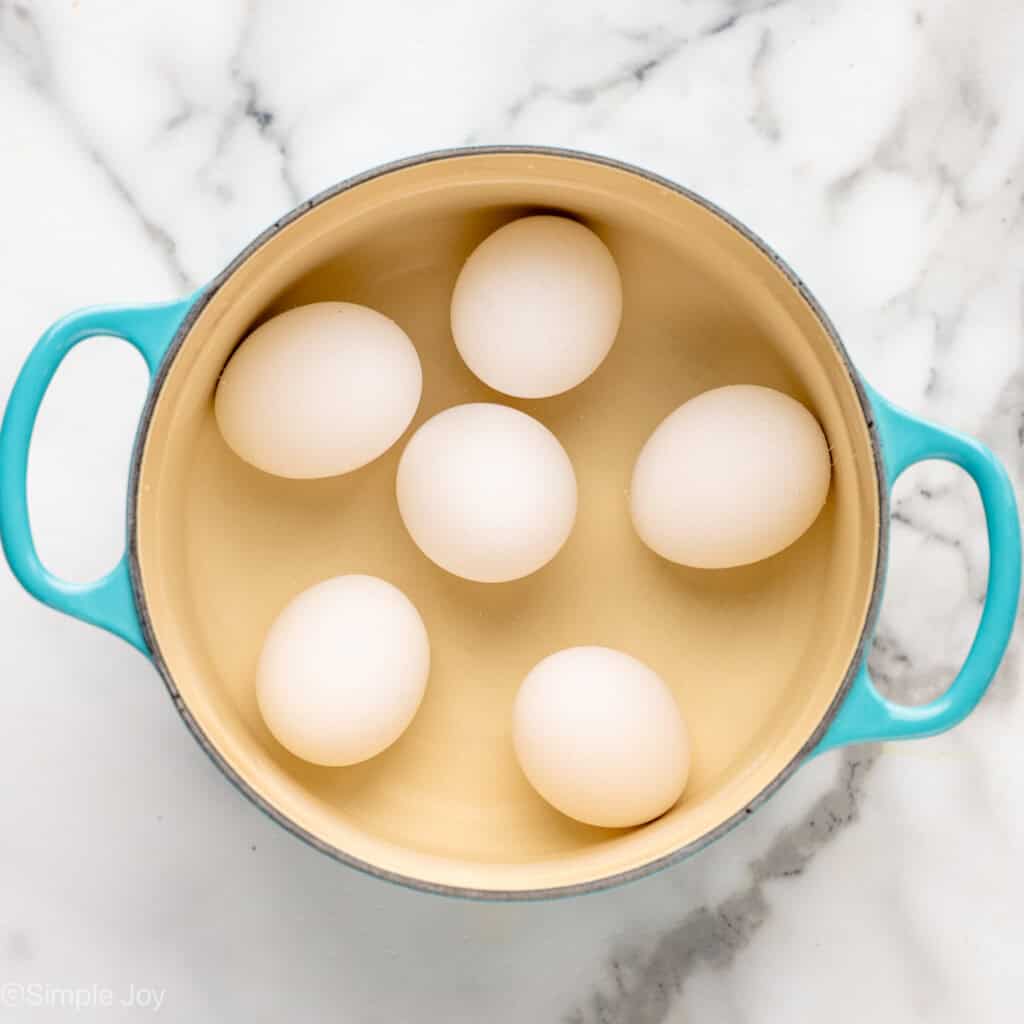 Overhead view of a pot with hard boiled eggs for Deviled Eggs with Bacon recipe