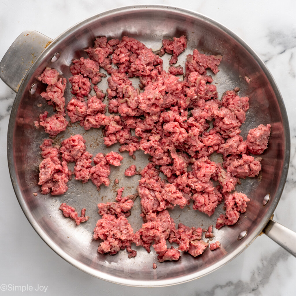 Overhead view of a skillet of raw ground beef for Lasagna Roll Ups recipe