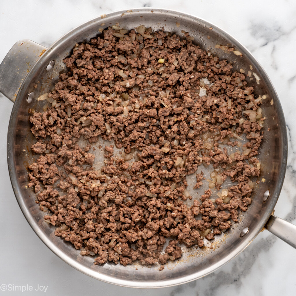 Overhead view of a skillet of browned ground beef for Lasagna Roll Ups recipe