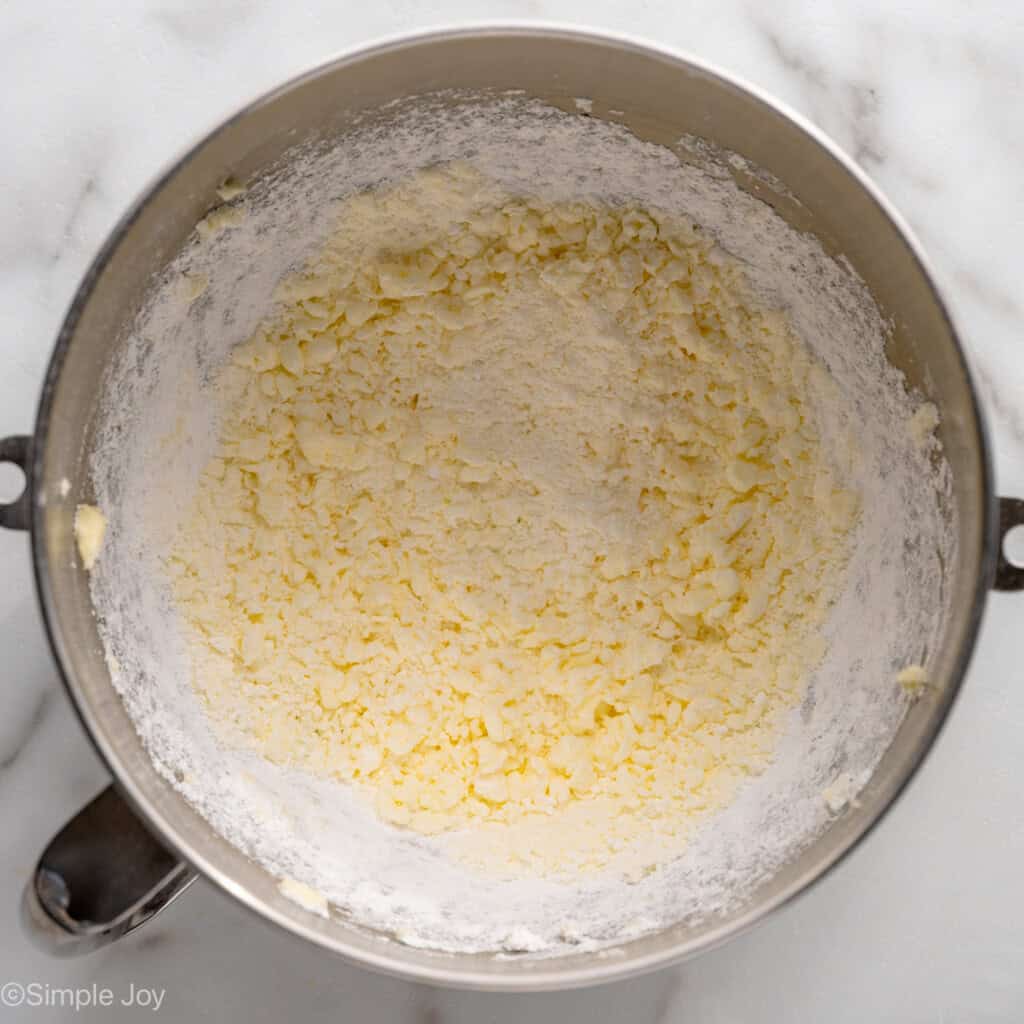 Overhead view of a mixing bowl of creamed butter and powdered sugar for Lemon Sugar Cookie Bars frosting recipe