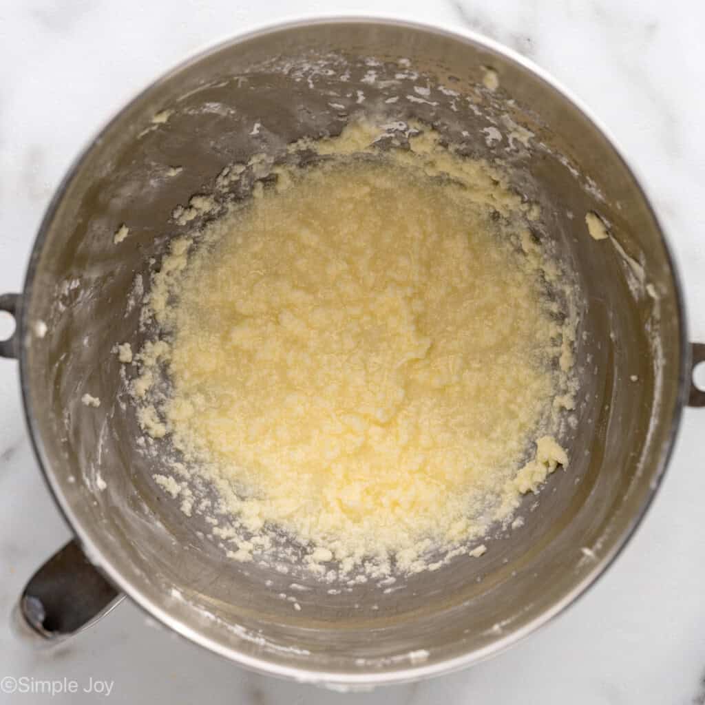 Overhead view of ingredients combined in a mixing bowl for Lemon Sugar Cookie Bars frosting recipe