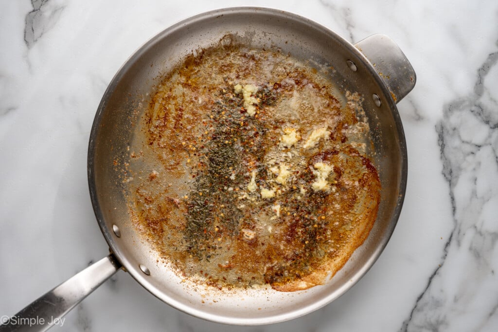 overhead of skillet of garlic and seasonings to make Marry Me Chicken
