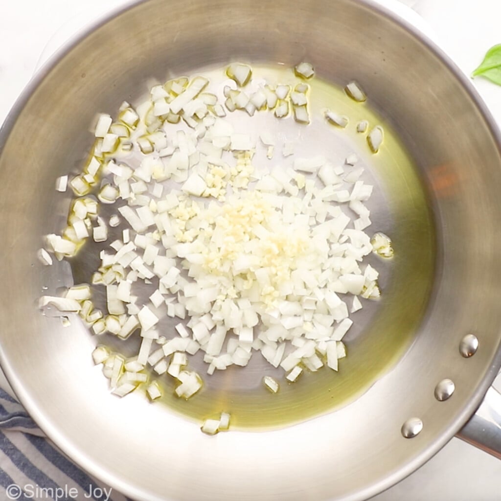 overhead of skillet of oil, onion, and garlic to make spinach quiche