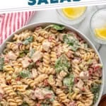 Pinterest graphic for chicken pasta salad. Image shows overhead of white bowl of chicken pasta salad. Says "the best chicken pasta salad simplejoy.com"