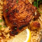 Pinterest graphic for Chicken and Rice. Image shows close up of chicken and rice with lemon and parsley. Says "super easy chicken & rice simplejoy.com"