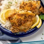 Pinterest graphic for Greek Chicken. Image shows plate of Greek Chicken with rice, garnished with lemon slices and parsley