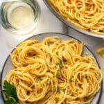 Pinterest graphic for lemon pasta. Says "the best lemon pasta simplejoy.com" Image shows overhead of plate of lemon pasta garnished with fresh parsley and lemon slices, glass of white wine, lemon pasta, and parsley sitting beside.