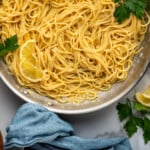 Pinterest graphic for lemon pasta. Image shows overhead of skillet of lemon pasta recipe garnished with parsley and lemon slices. Says "super easy lemon pasta simplejoy.com"