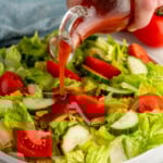 catalina dressing being poured on a salad
