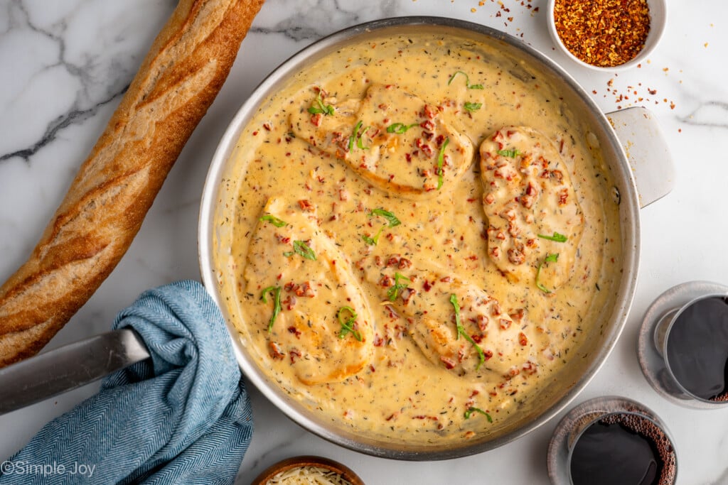 overhead of a pan of marry me chicken garnished with basil
