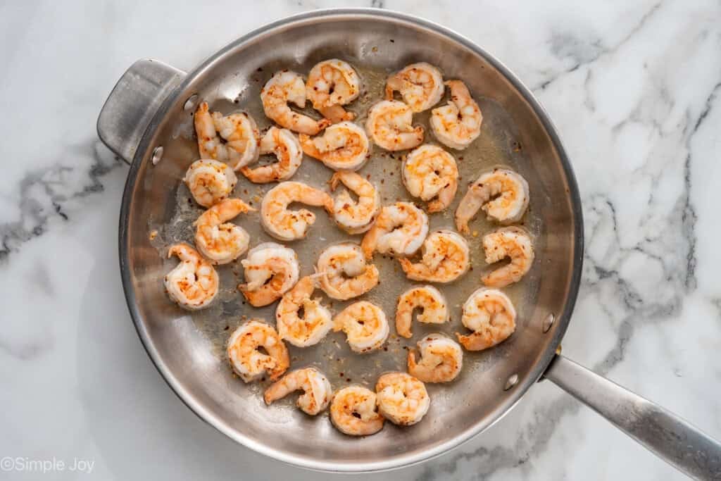 Overhead of skillet cooking shrimp with seasonings for shrimp fra diavolo recipe