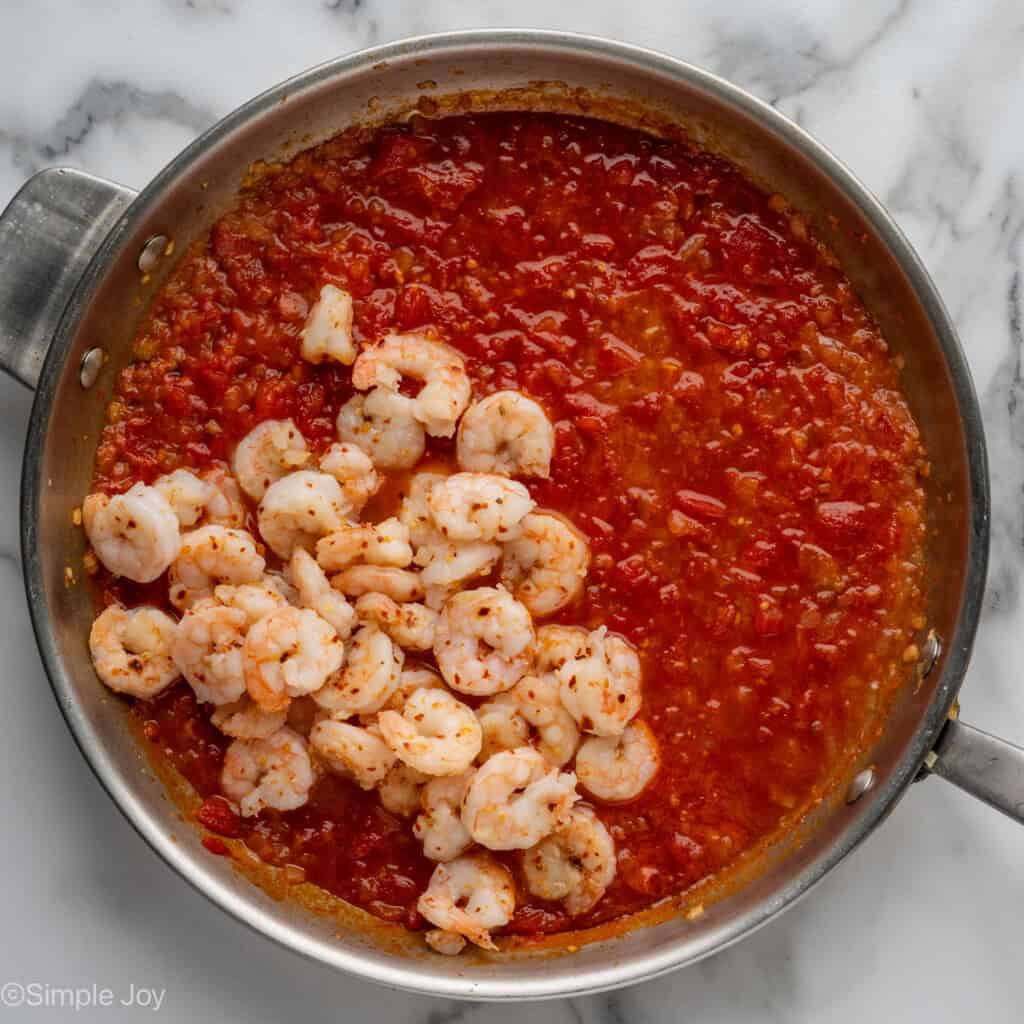 Overhead of skillet of Shrimp Fra Diavolo sauce ingredients and cooked shrimp