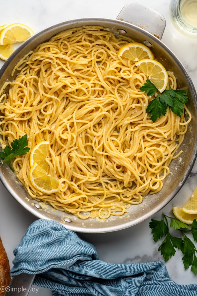 Overhead of skillet of lemon pasta garnished with parsley and lemon slices