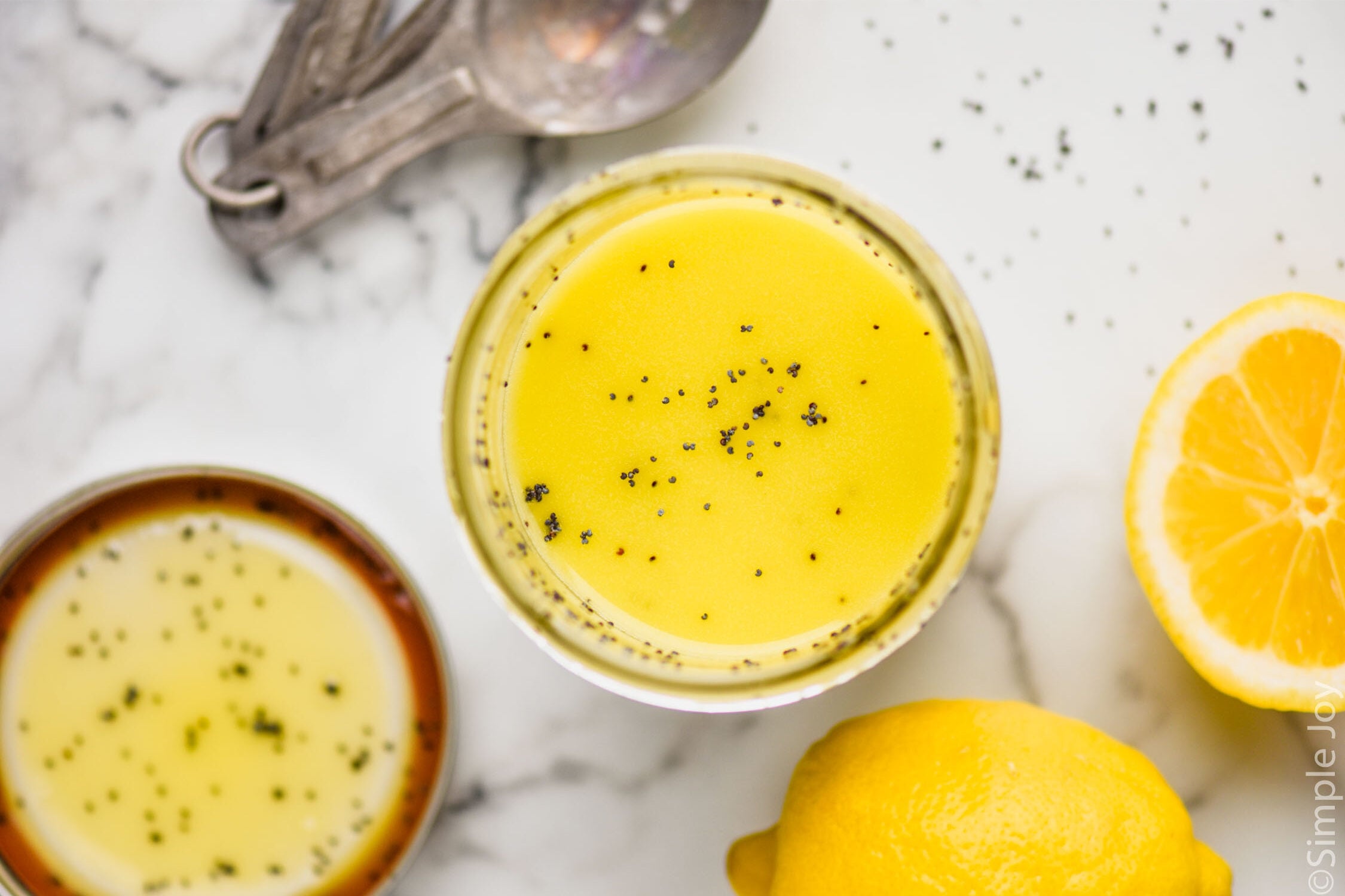 Overhead view of jar of Poppy Seed Dressing with sliced lemon beside