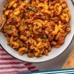 Pinterest graphic for American Chop Suey. Image shows overhead of bowl of American Chop Suey with spoon. Says "American Chop Suey simplejoy.com"