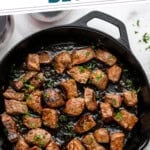 Pinterest graphic for Garlic Butter Steak Bites. Says "the best Garlic Butter Steak Bites simplejoy.com" Image shows overhead of skillet of Garlic Butter Steak Bites garnished with parsley