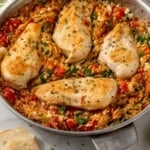 Pinterest graphic for Mediterranean Chicken and Orzo. Image shows a skillet of Mediterranean Chicken and Orzo, says "one pot Mediterranean Chicken and Orzo simplejoy.com