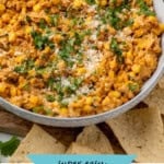 Pinterest graphic for Mexican Street Corn Dip. Image shows a bowl of Mexican Street Corn Dip garnished with cilantro and lime wedges, tortilla chips sitting beside. Says "super easy mexican street corn dip simplejoy.com"