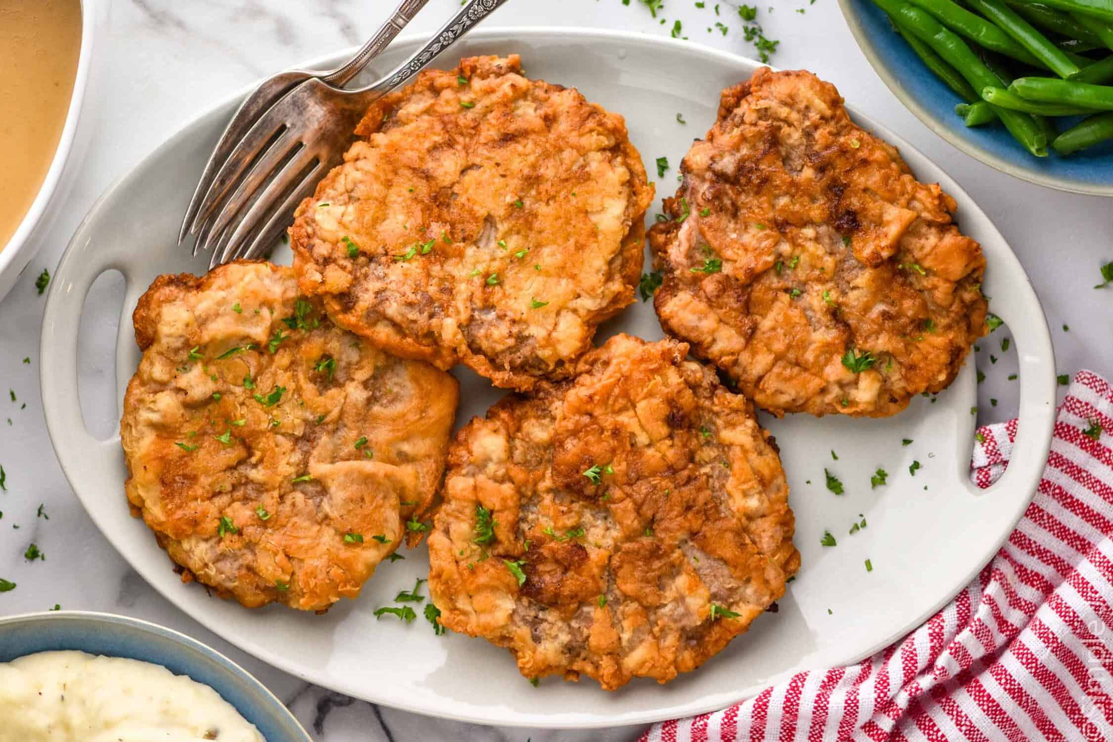 overhead of cooked Chicken Fried Steak with two forks for serving