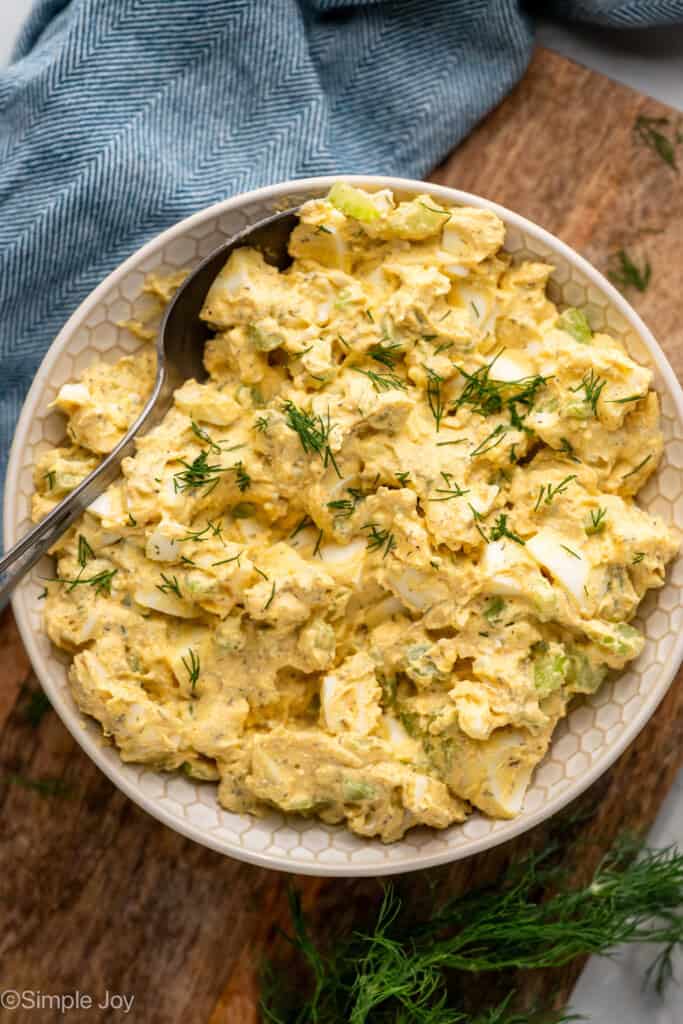 Overhead of bowl of Cottage Cheese Egg Salad garnished with fresh dill and spoon