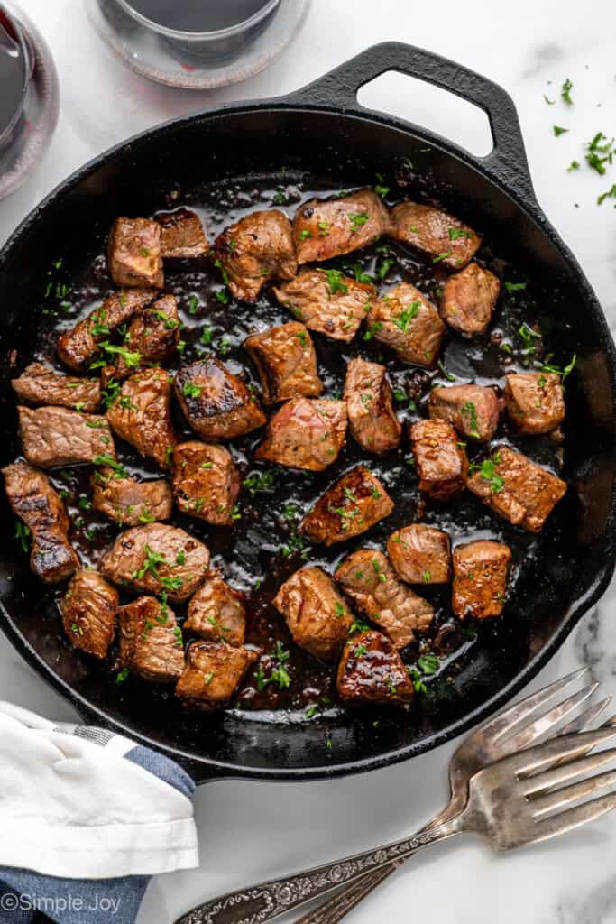 Overhead of skillet of Garlic Butter Steak Bites garnished with fresh parsley