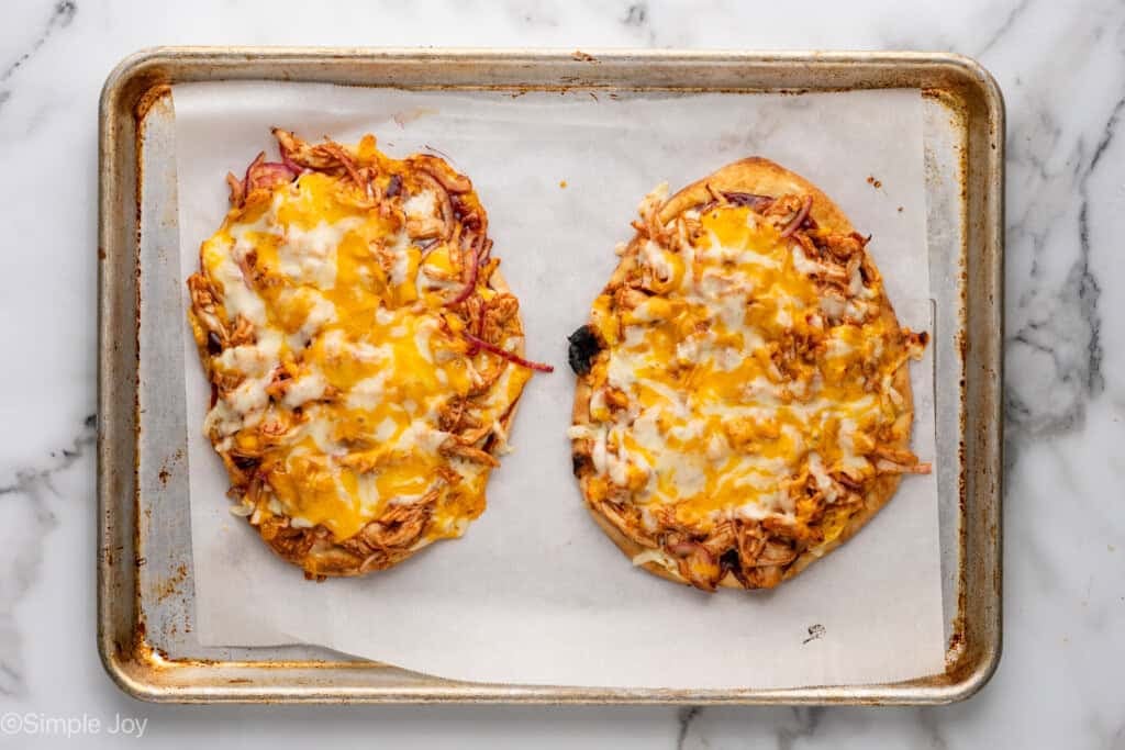 Overhead of baking sheet with two BBQ Chicken Flatbread Pizzas