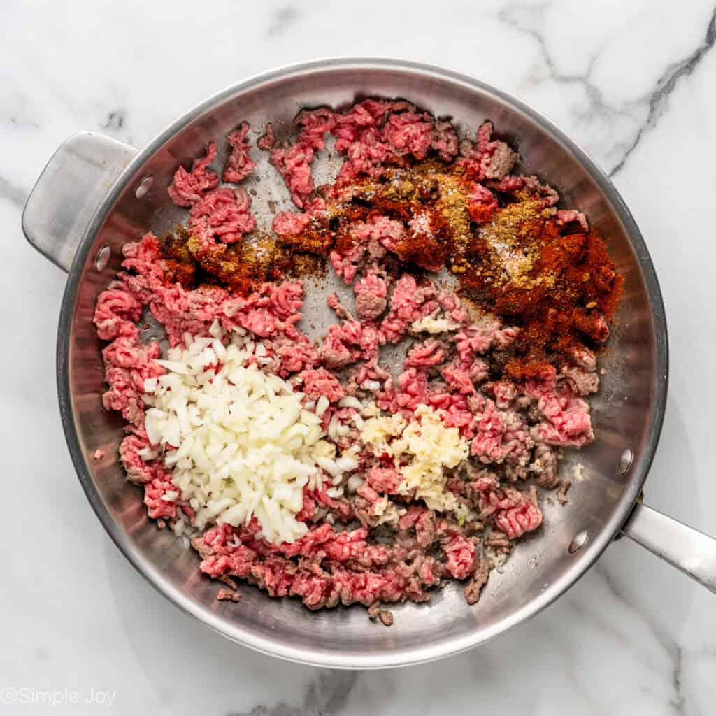 Overhead of skillet of Baked Beef and Cheese Chimichangas ingredients