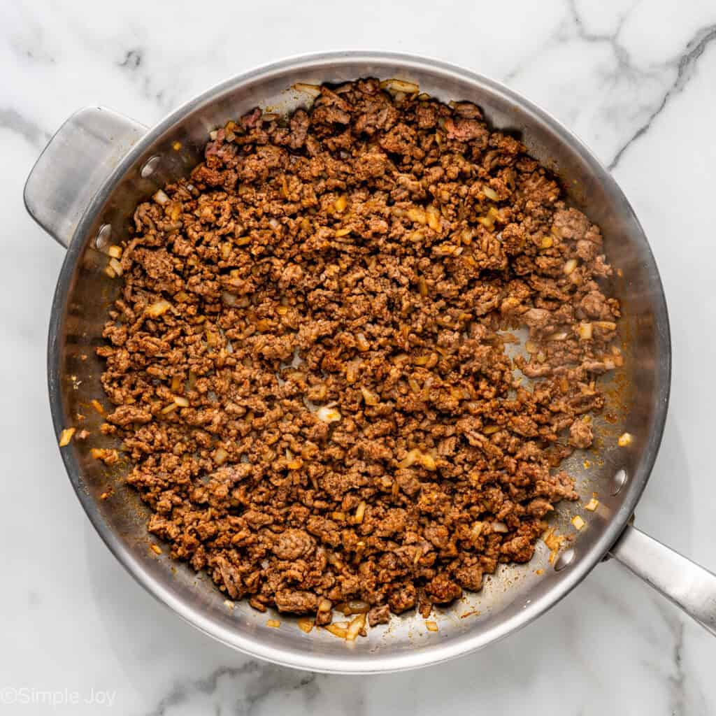 Overhead of skillet of Baked Beef and Cheese Chimichangas ingredients