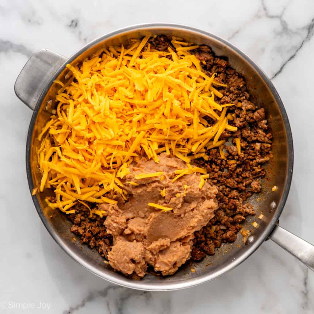 Overhead of skillet of Baked Beef and Cheese Chimichangas ingredients