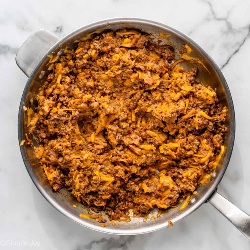 Overhead of skillet of Baked Beef and Cheese Chimichangas ingredients