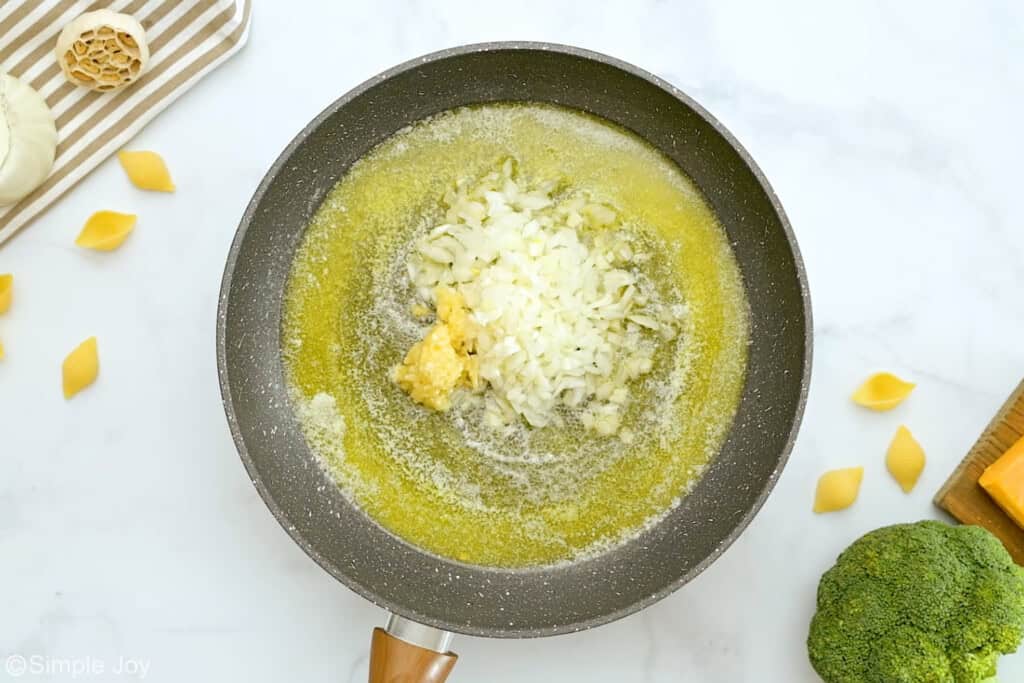 overhead of onion and garlic sautéing in a pan