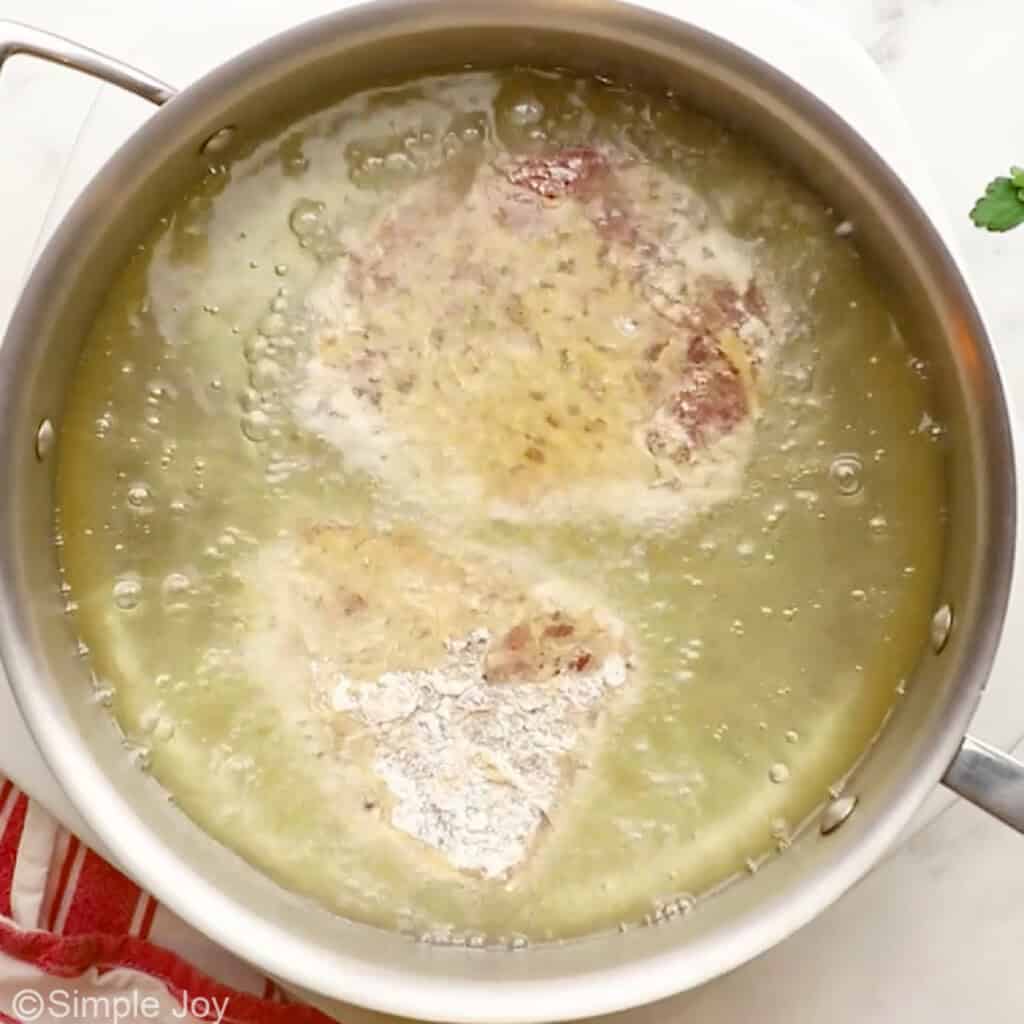 Overhead of skillet of oil frying steak for Chicken Fried Steak recipe