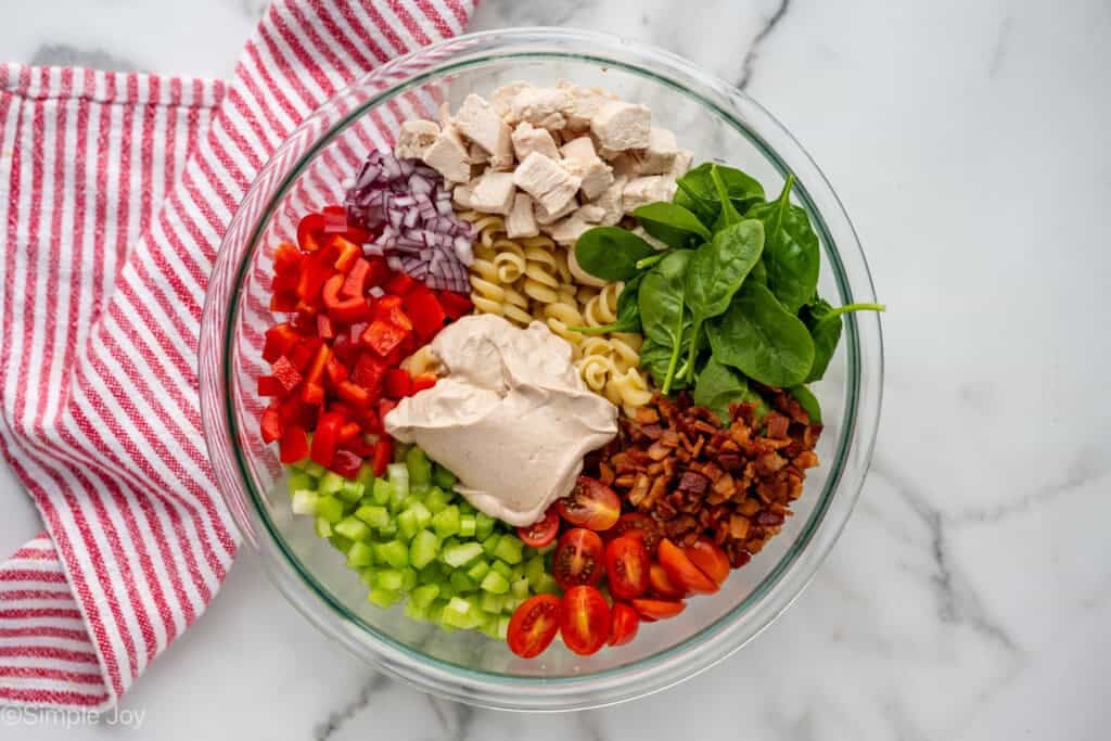 overhead of ingredients for chicken pasta salad in a bowl