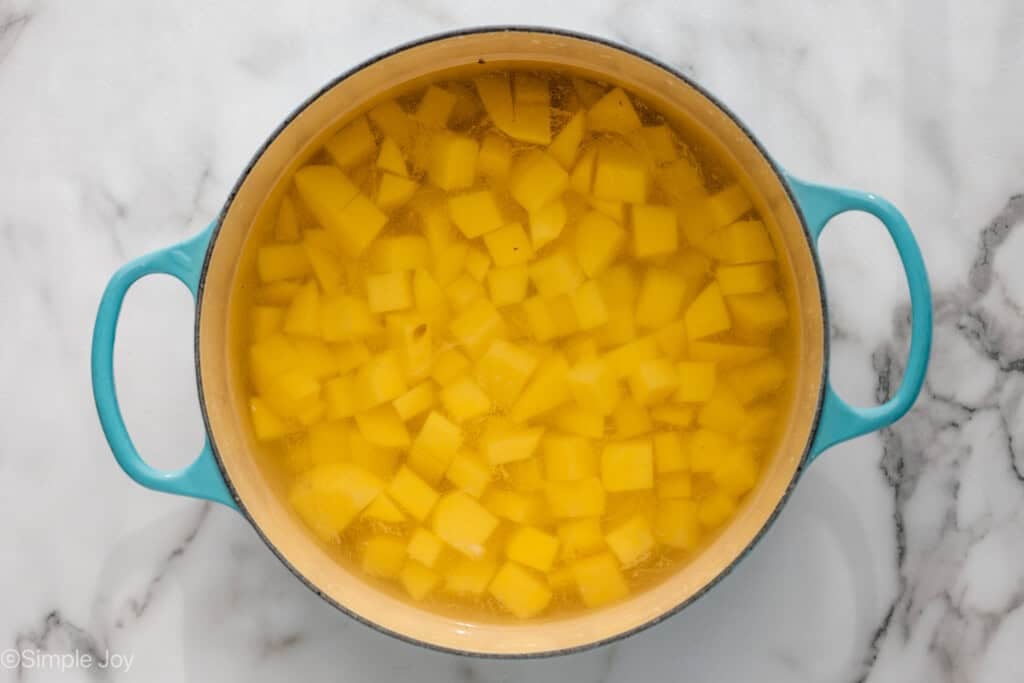Overhead of large stock pot of diced potatoes in water to make deviled egg potato salad