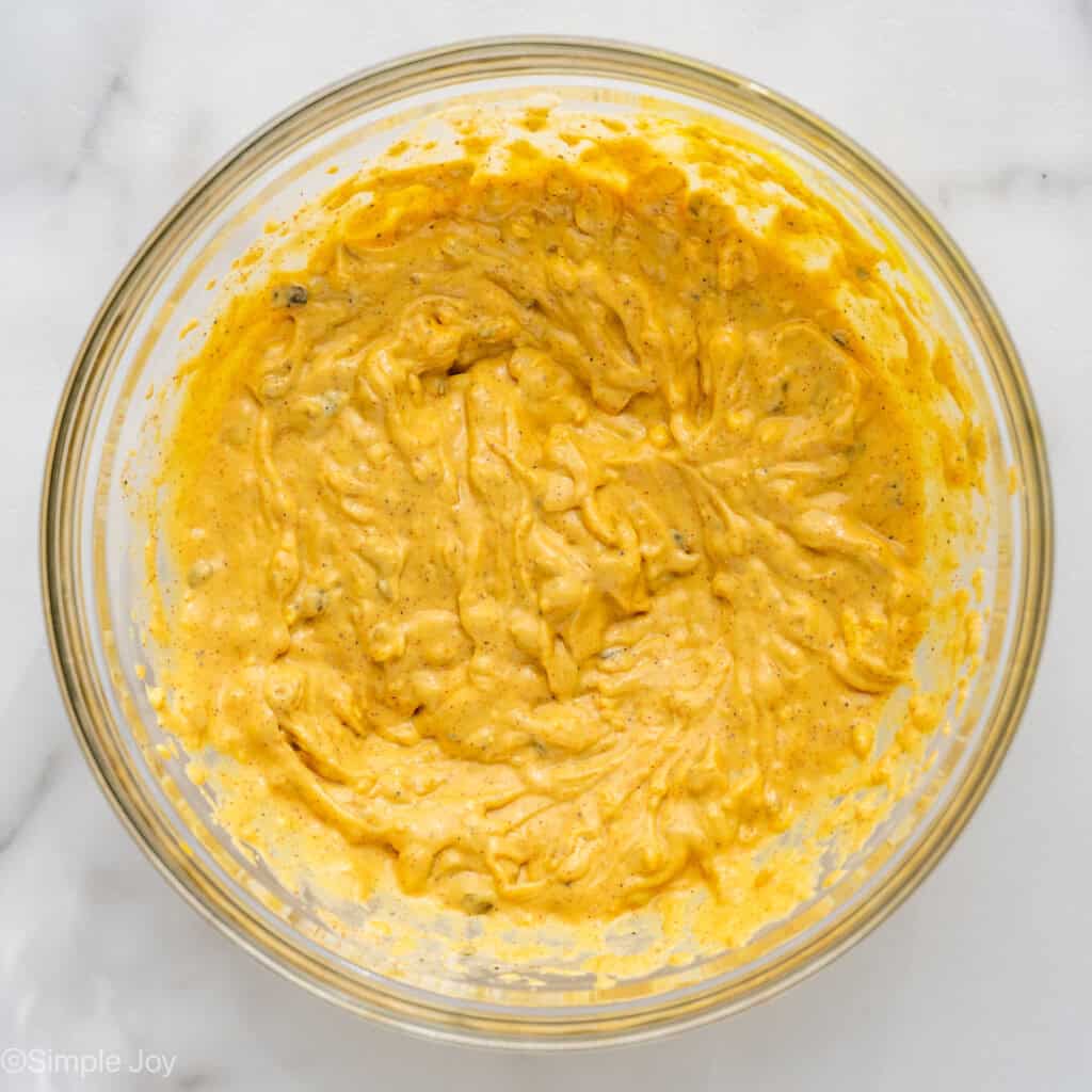 Overhead of glass bowl of Deviled Egg Potato Salad ingredients