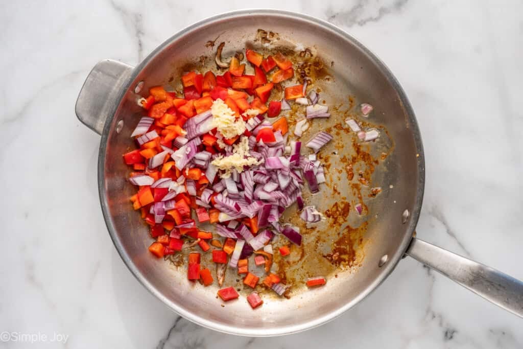 Overhead of skillet of Mediterranean Chicken and Orzo ingredients